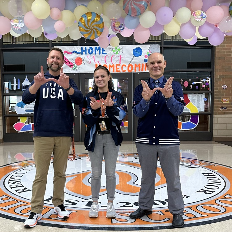 three staff members holding Ws