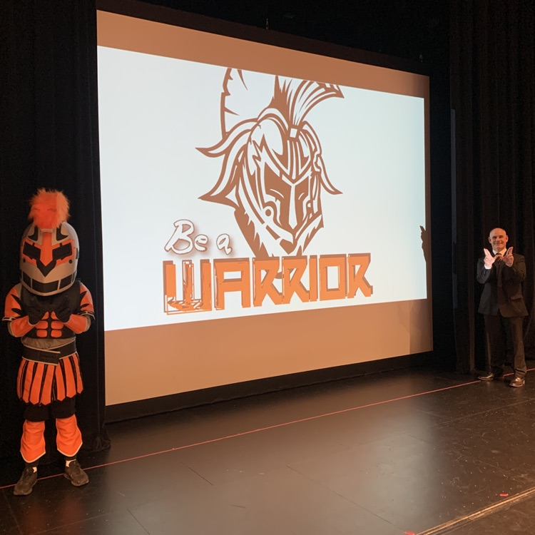 principal in front of Be A Warrior graphic