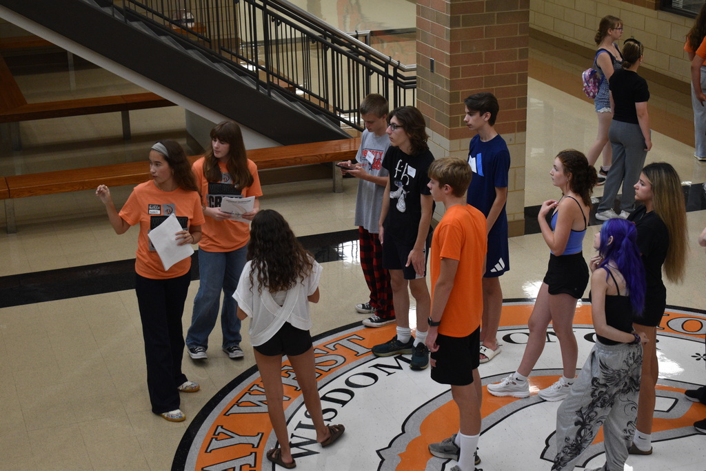 Students standing in the lobby of the school getting a tour