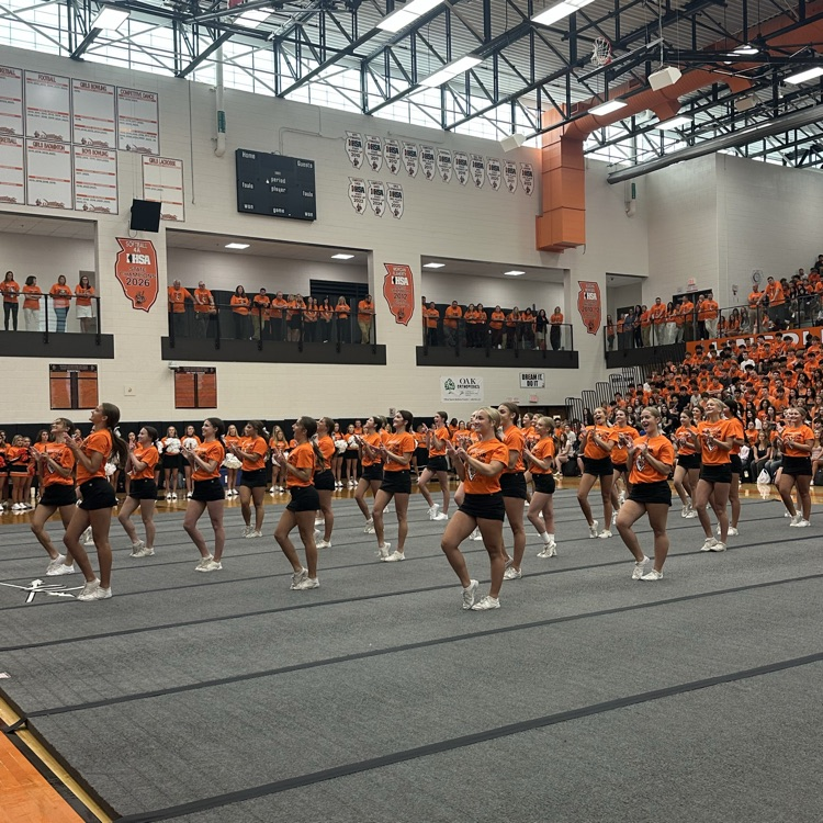 cheerleaders in the gym at the end of their performance 