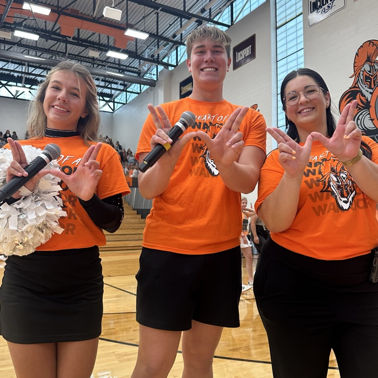 two student emcees and staff member holding Ws with hands