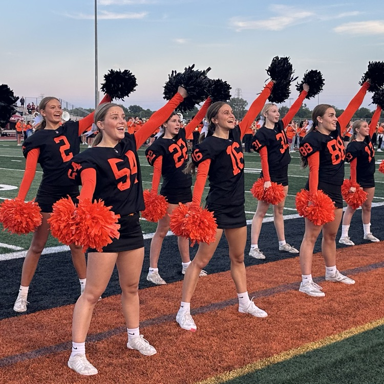 cheerleaders cheer on the track during football game