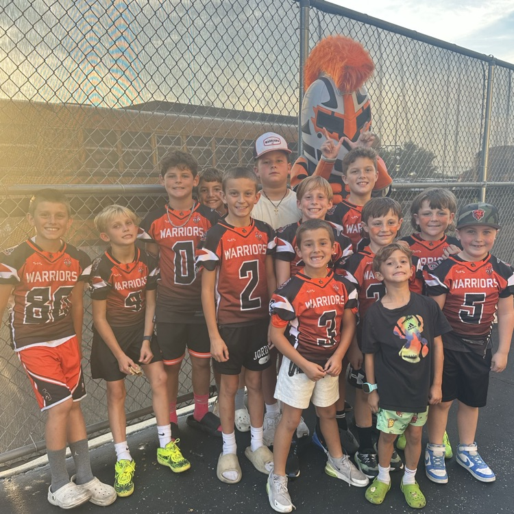 group of youth football players with warrior mascot