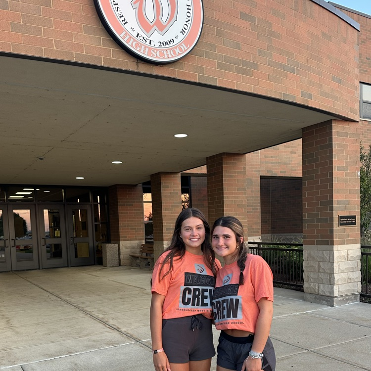 two students in front of the school building