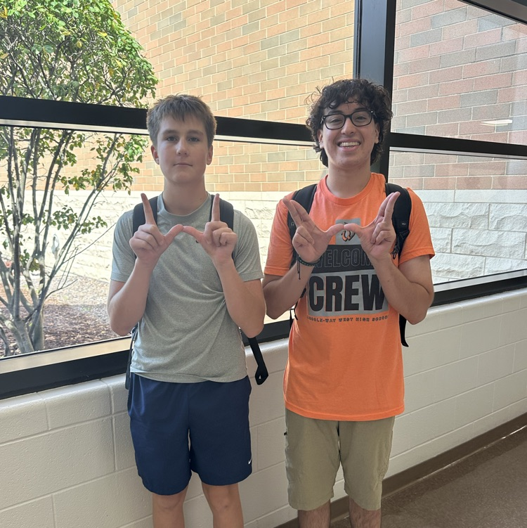 two students holding up Ws
