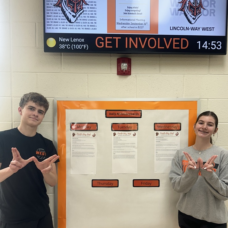 two students in front of bulletin board announcements