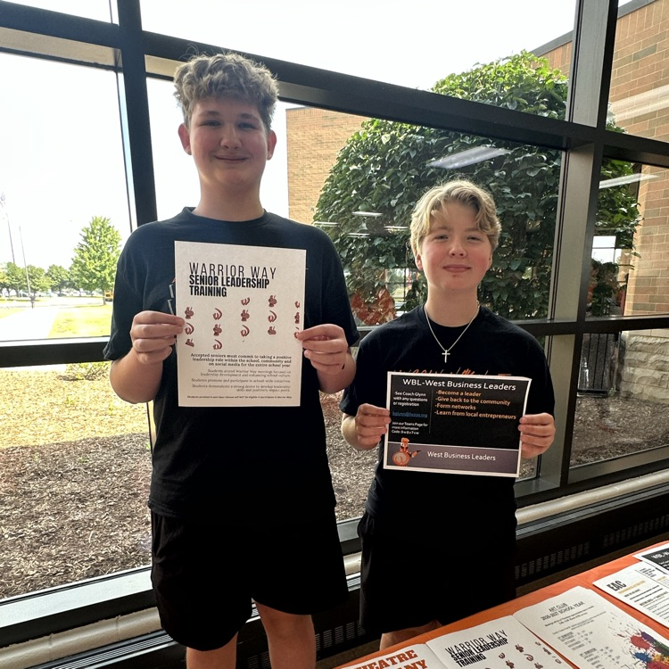two students holding activity flyers