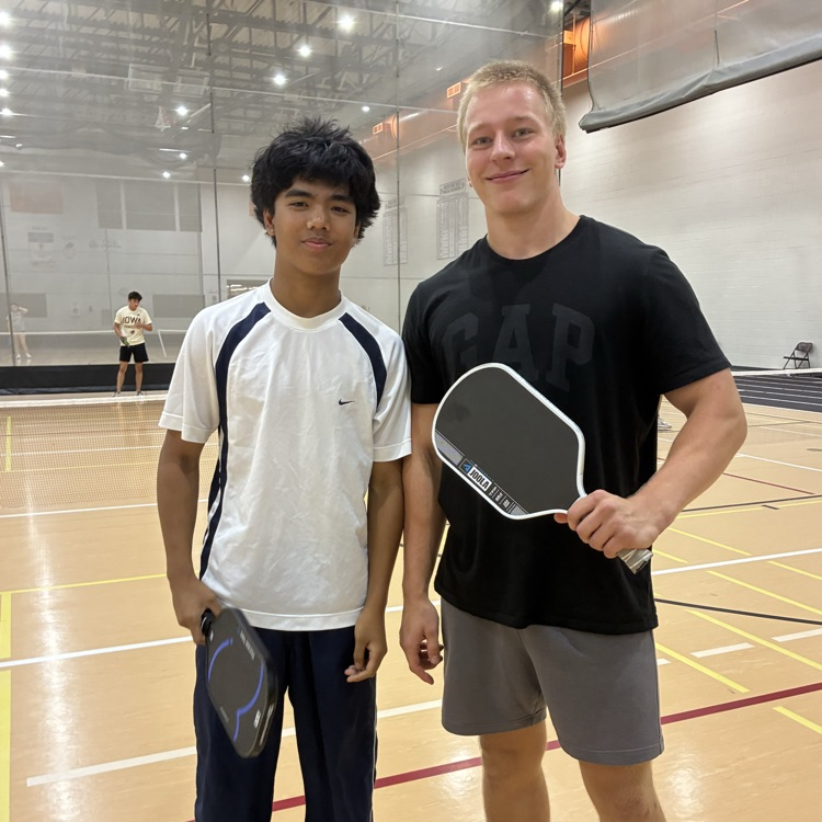 students with pickelball paddles in the fieldhouse