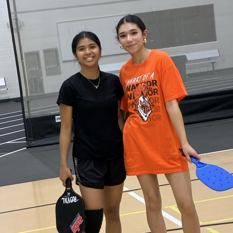 students posing for a photo with pickleball paddles