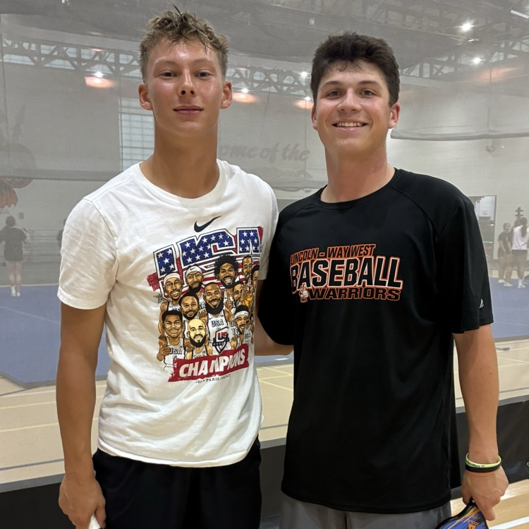 two students posing for a photo in the fieldhouse