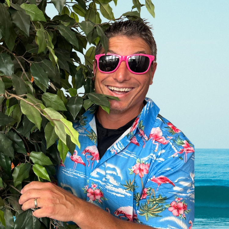 staff member in tropical shirt and sunglasses in front of tree