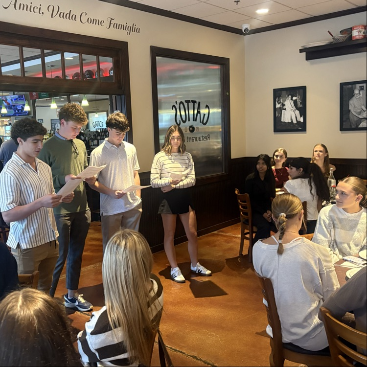 students presenting in front of the group at restaurant