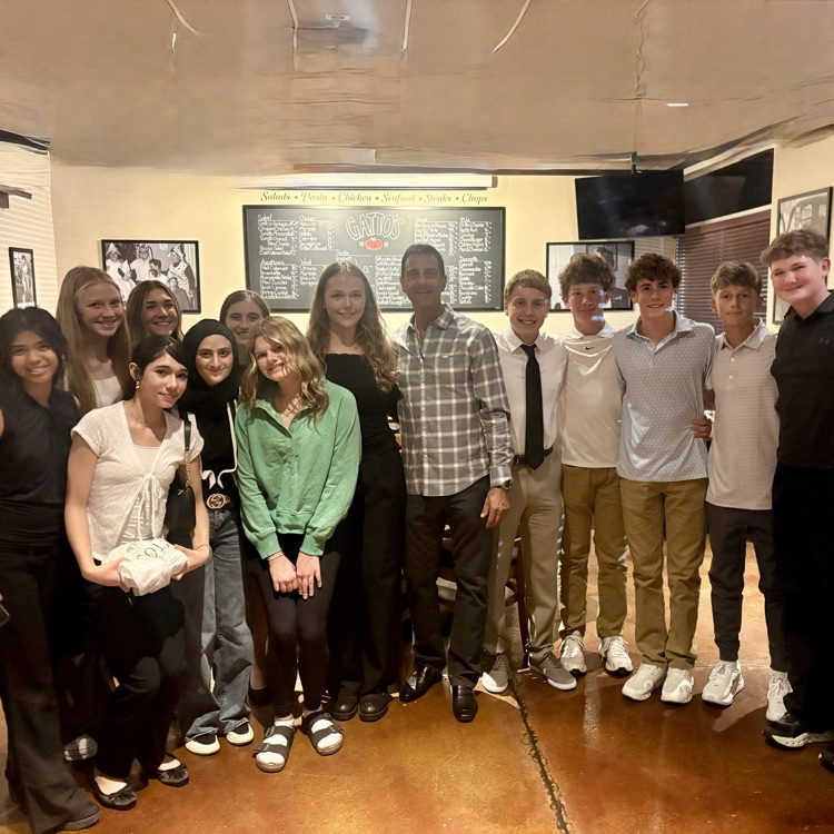students posing for a picture with business owner