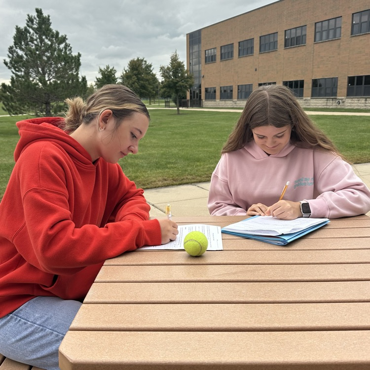 two students working on physics lab at table