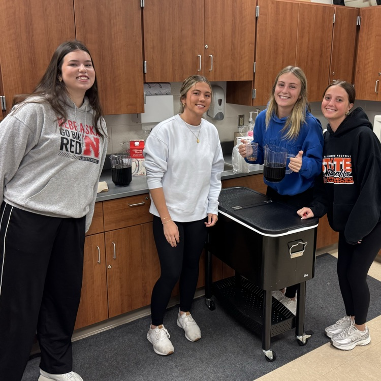students posing for a photo as they prepare coffee