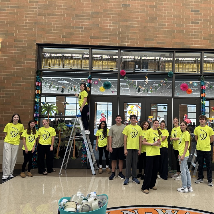 students in neon yellow shirts decorating for homecoming