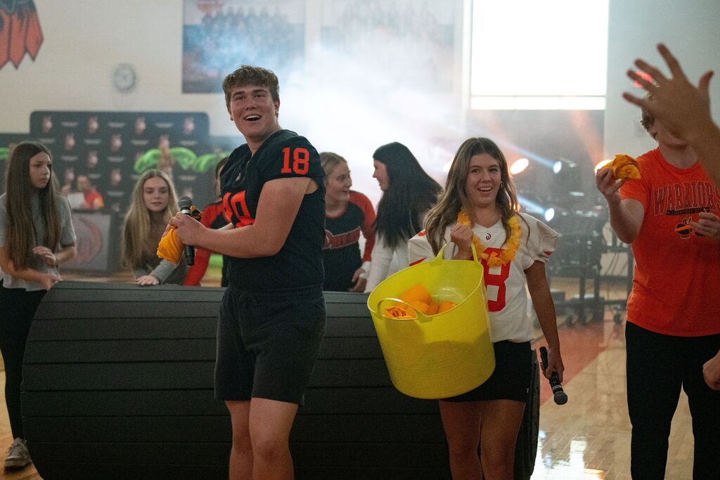 A group of people stand in a school gym.