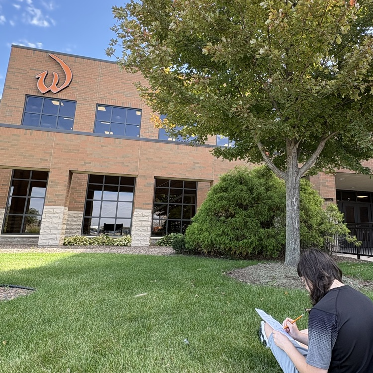 student studying in front of school building