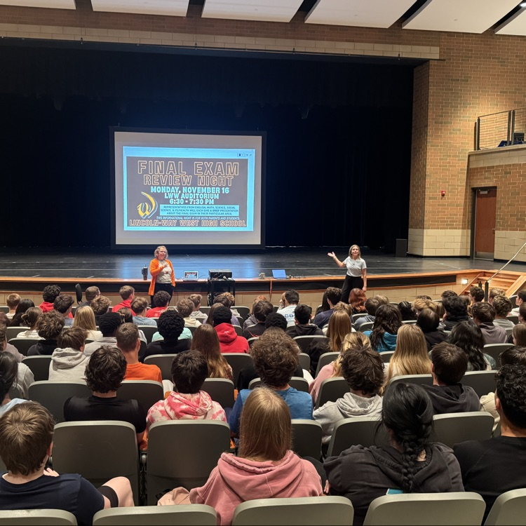teachers presenting to students in the auditorium