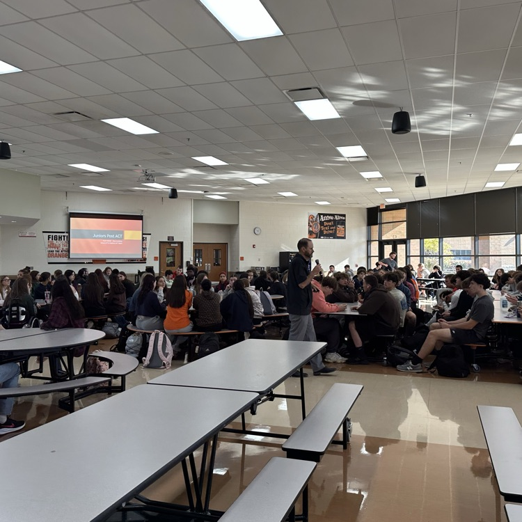 associate principal presenting to students in the cafeteria