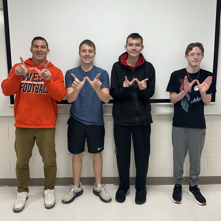 teacher and students posing for a photo with Ws