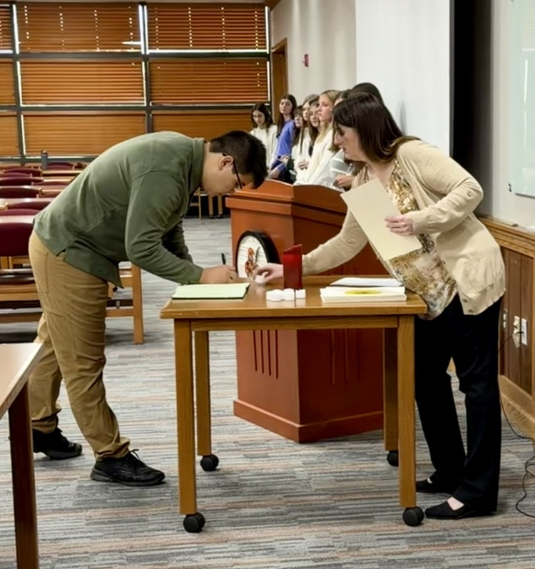 student signing document