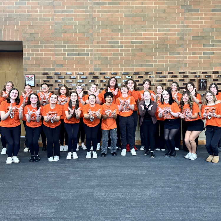 students from the choir holding up Ws