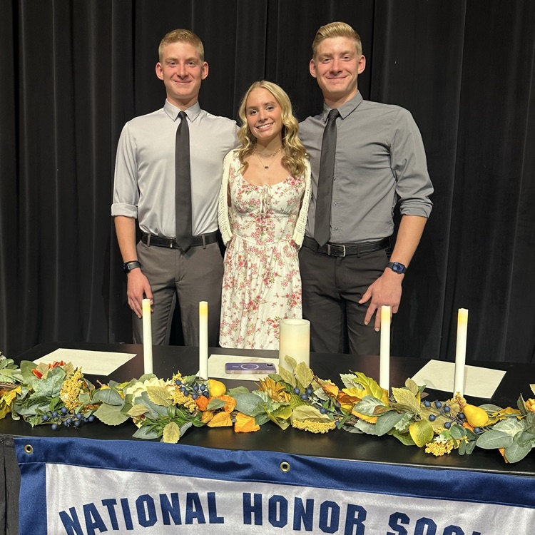 students posing for a photo in front of the NHS table