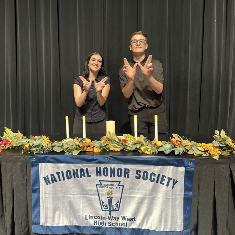 students taking a photo in front of the NHS table