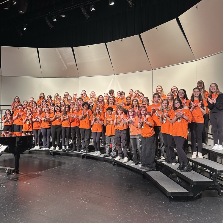 students holding Ws on stage