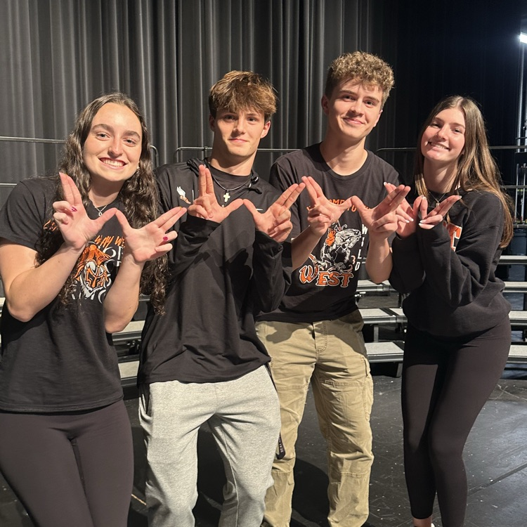 students wearing school spirit wear and holding Ws