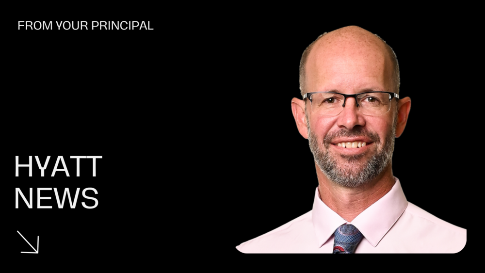 Picture of male principal wearing a pink shirt and blue tie.