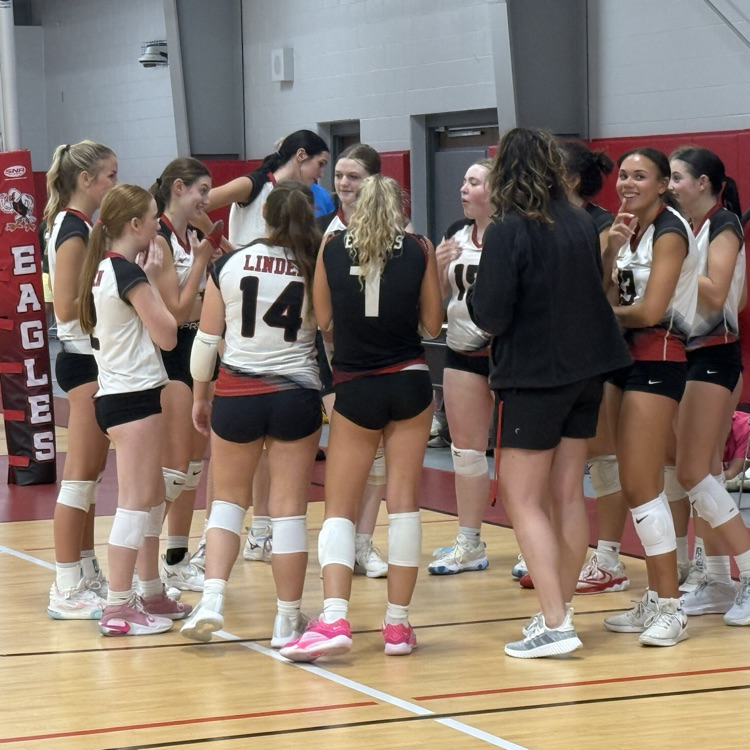 volleyball girls in huddle with coach