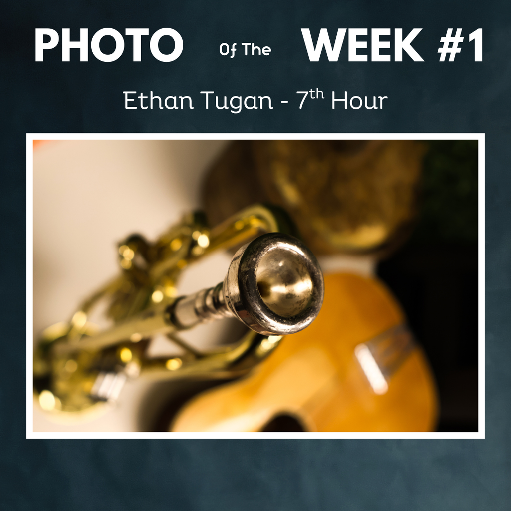 Photo of a trumpet mouth piece with guitar in background