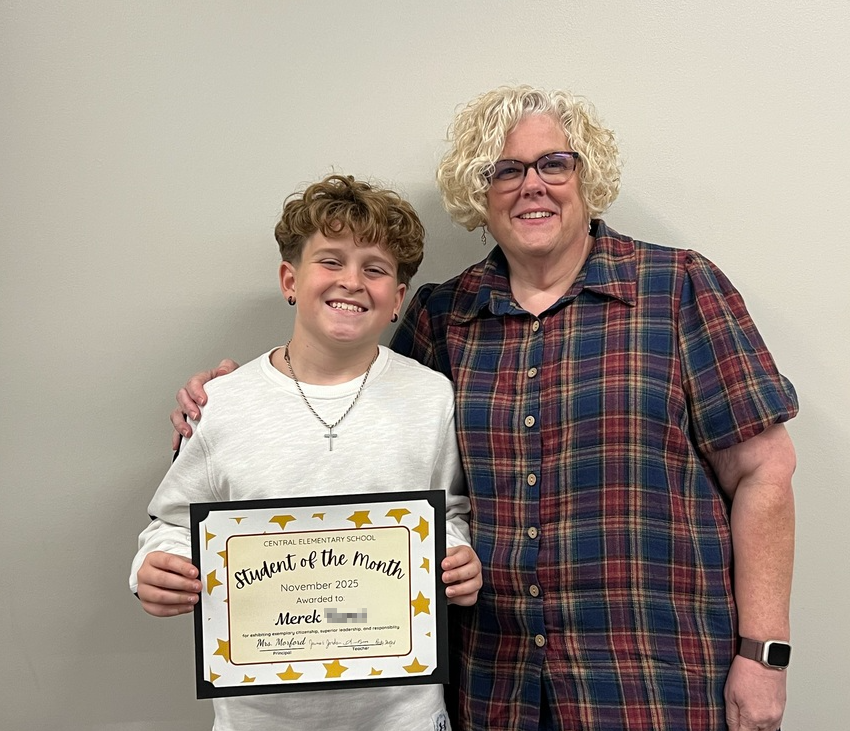 Student holding certificate standing with teacher