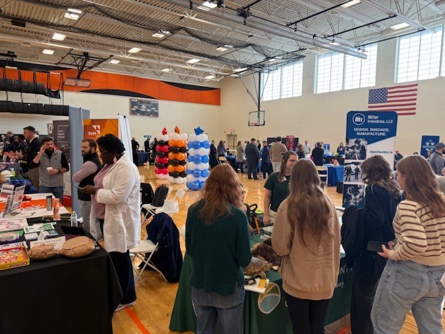 students visiting employer booths at a college and career fair