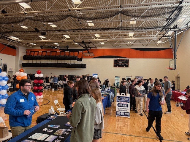 students visiting employer booths at a college and career fair