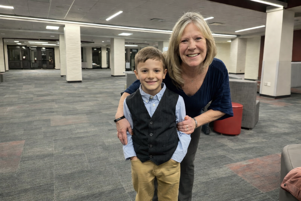 Adult female teacher smiling with 2nd grade male student