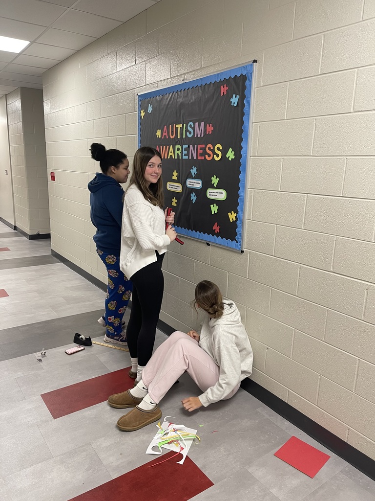 Students creating an Autism Awareness Bulletin Board