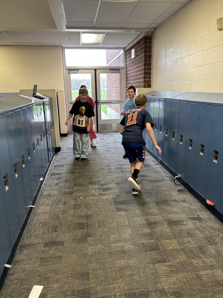 A group of students is working together on a science activity in the hallway. 