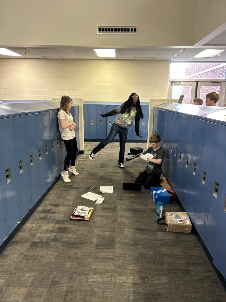 A young lady tries holding a yoga pose without a reference point while her friends time her / observe. 