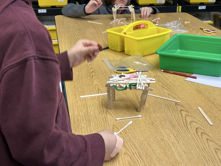 Students building a bridge out of materials  