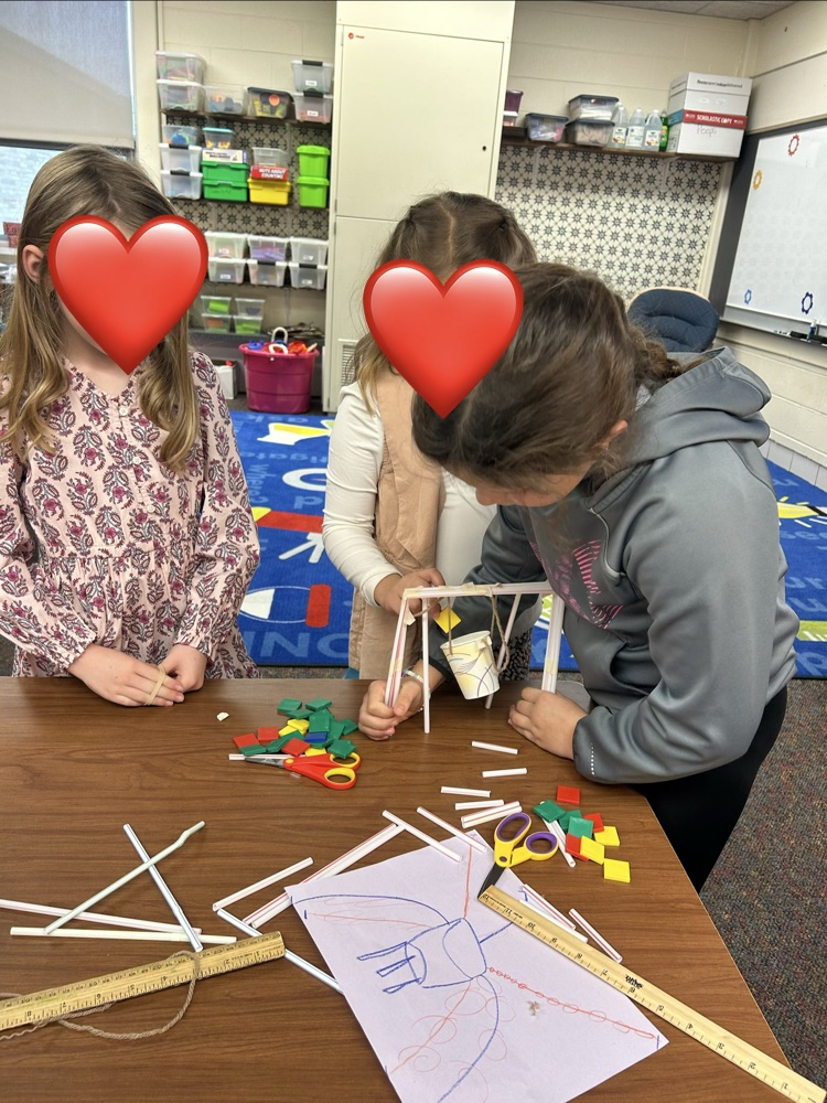 Students drawing a blueprint of their build 