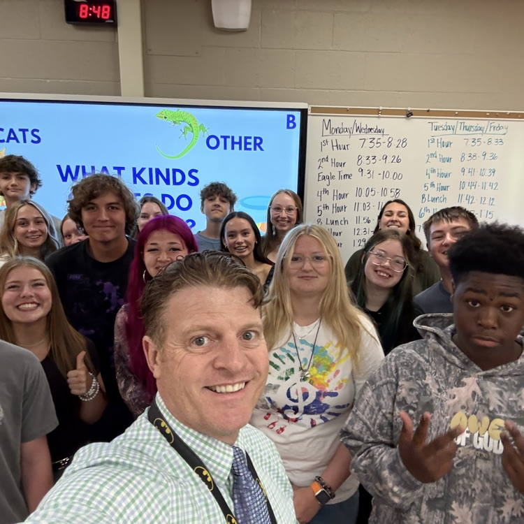 co- principal and students taking a picture in front of the board while they do teambuilding activities