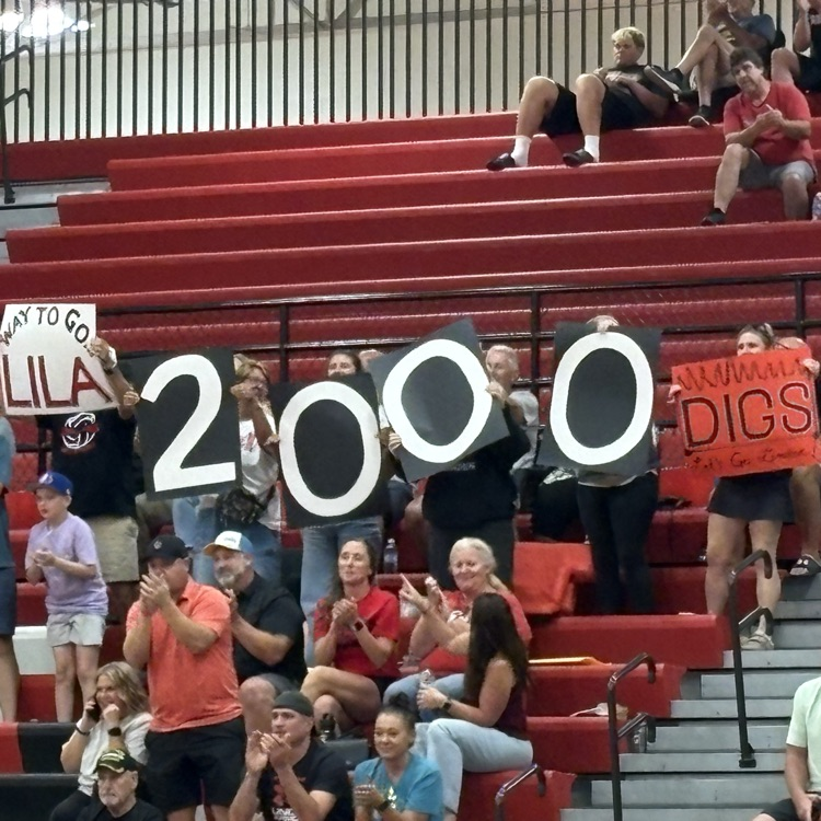 fans in the stand, holding up a sign