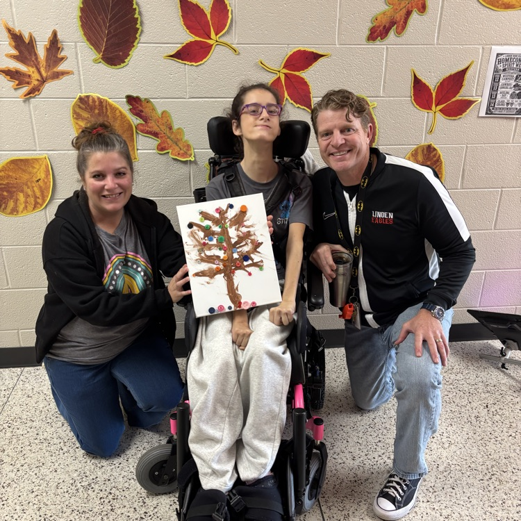 student and two staff showing fall artwork 