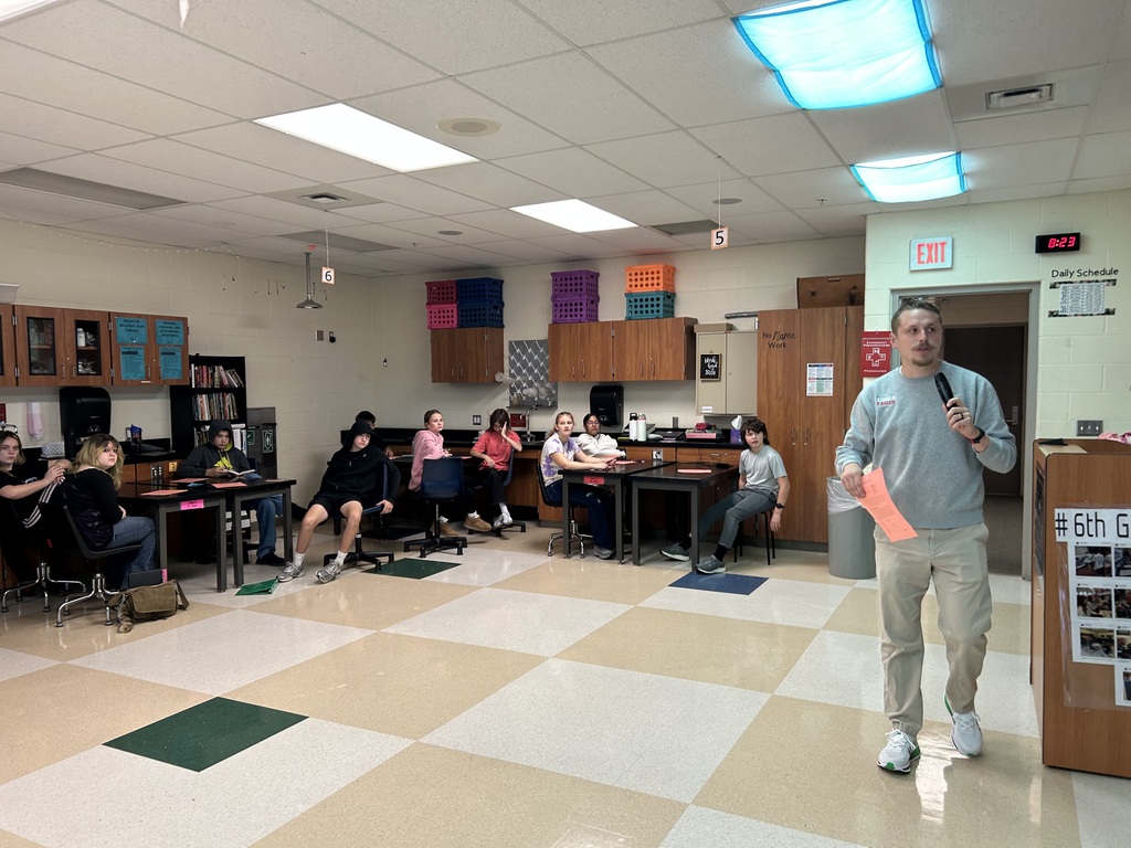 A teacher using his microphone to read options to students for an educational game.