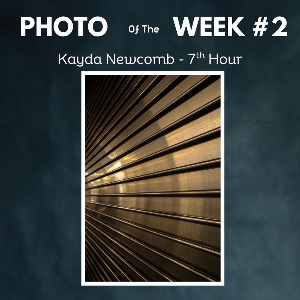 Graphic labeled "PHOTO of the WEEK #2" by student Kayda Newcomb (7th Hour), showcasing a photograph of golden light shining across a textured metal roll-up door.