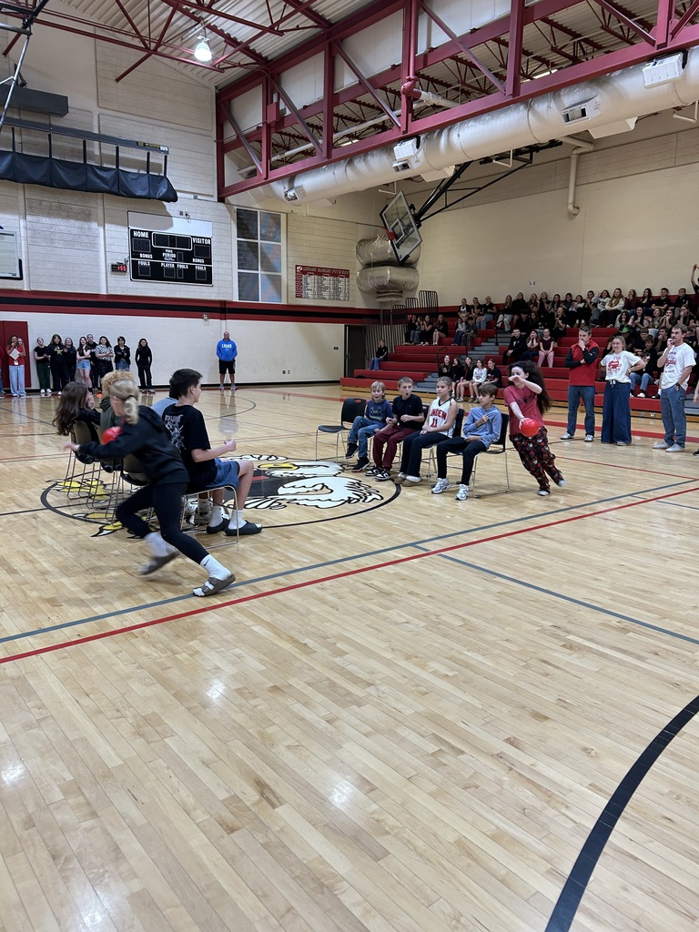 Students face off in a relay game involving a ball and running around in a circle