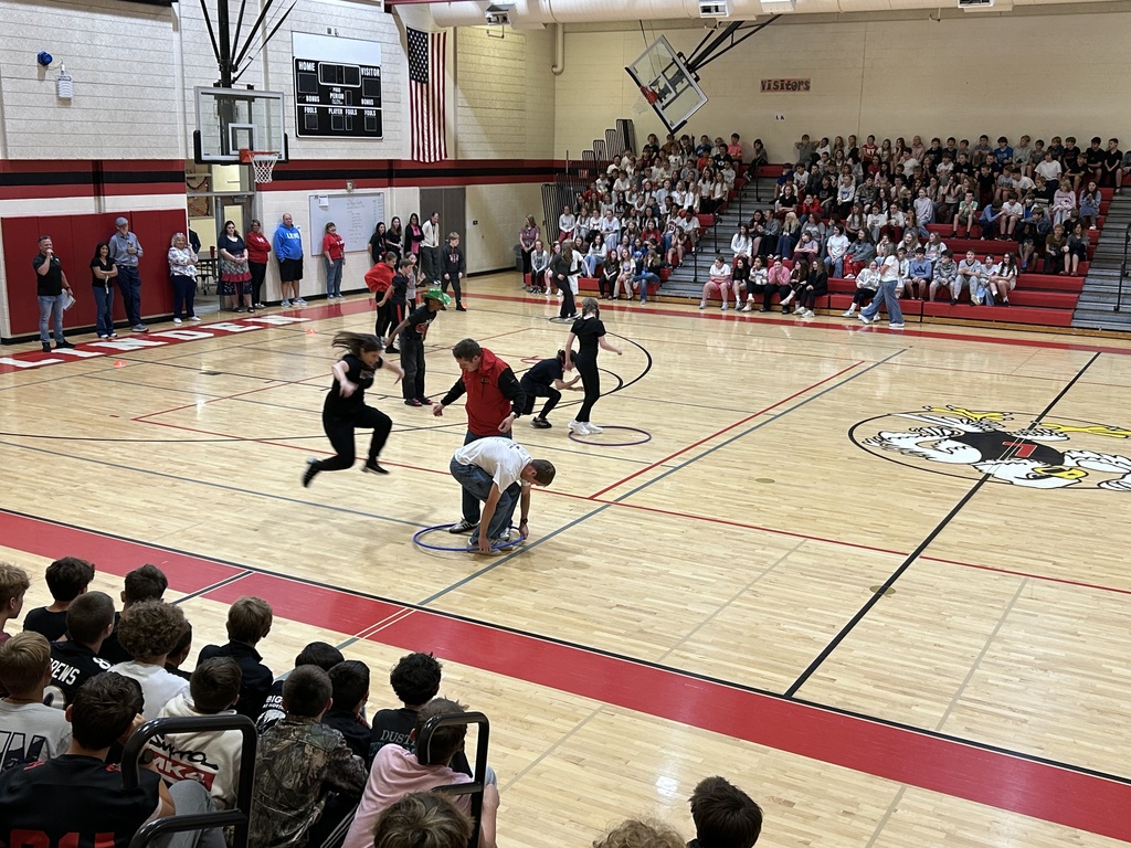 Staff and students compete against each other in a hula hoop relay race